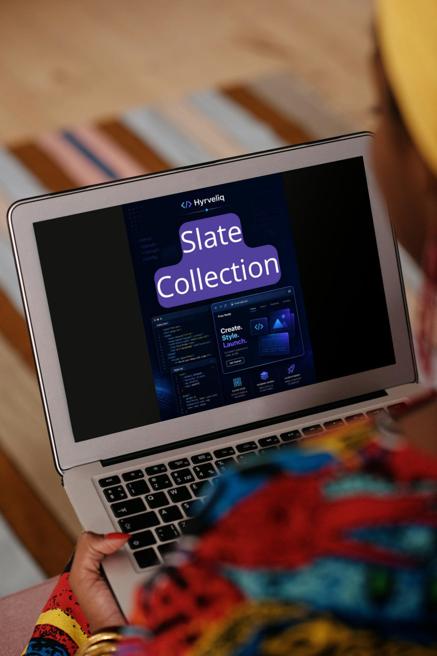 Person using a laptop with a screen displaying 'Slate Collection' on a wooden surface.